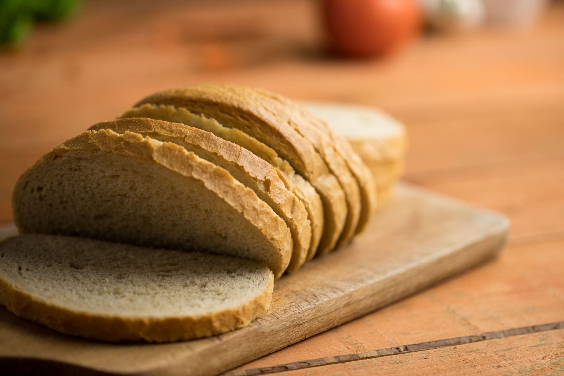 Slices of soft white sandwich loaf on a rustic wooden board