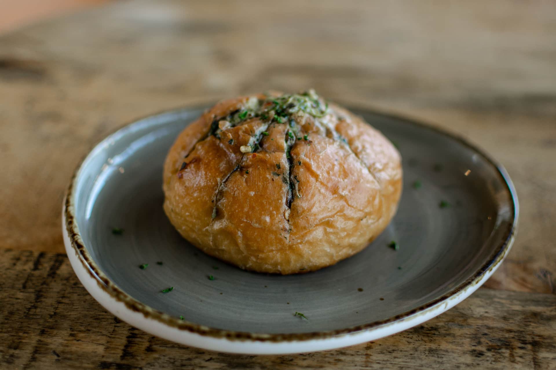 A domed ceramic baking cloche on a plain kitchen surface