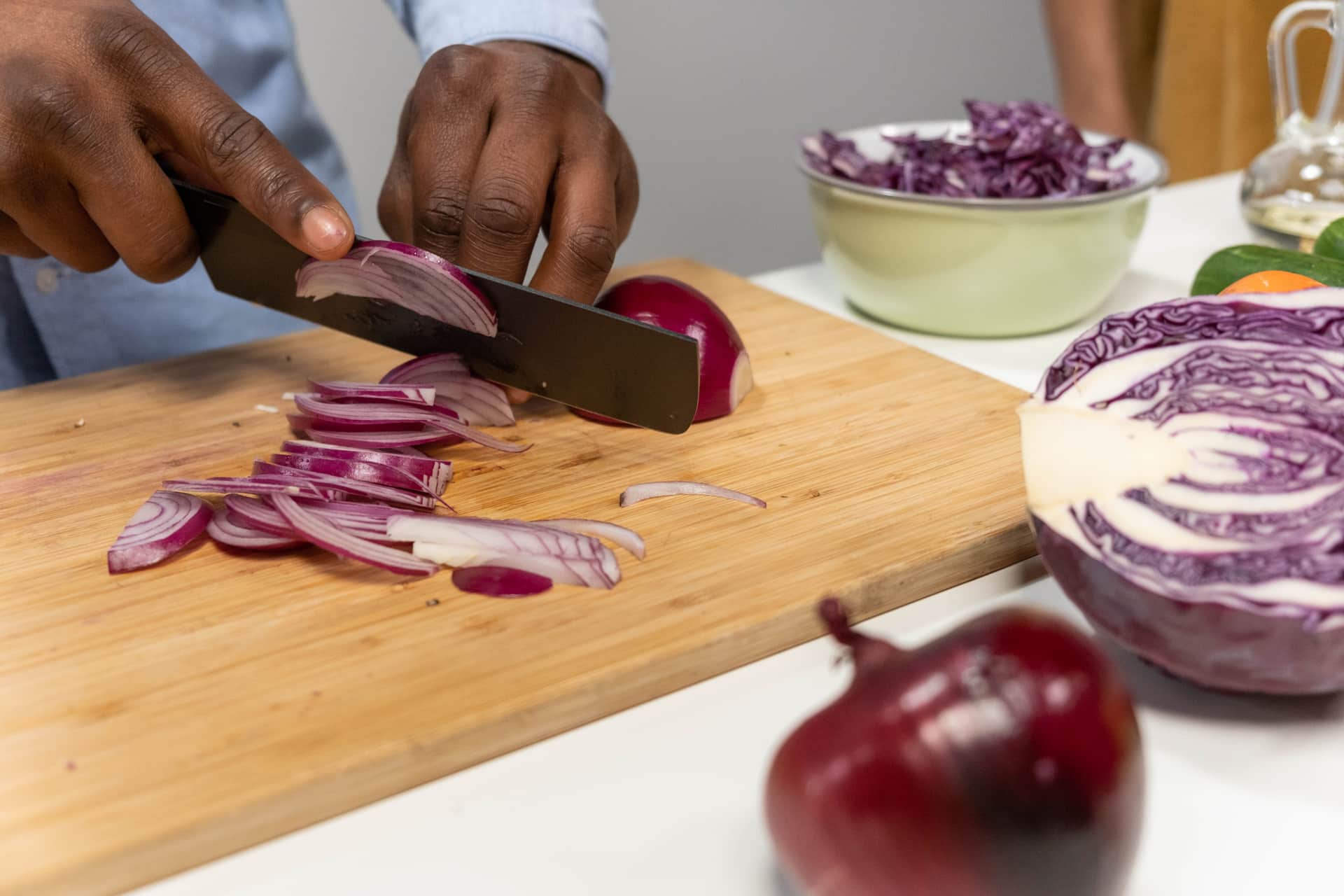 Sliced red onion and red cabbage on a wooden chopping board