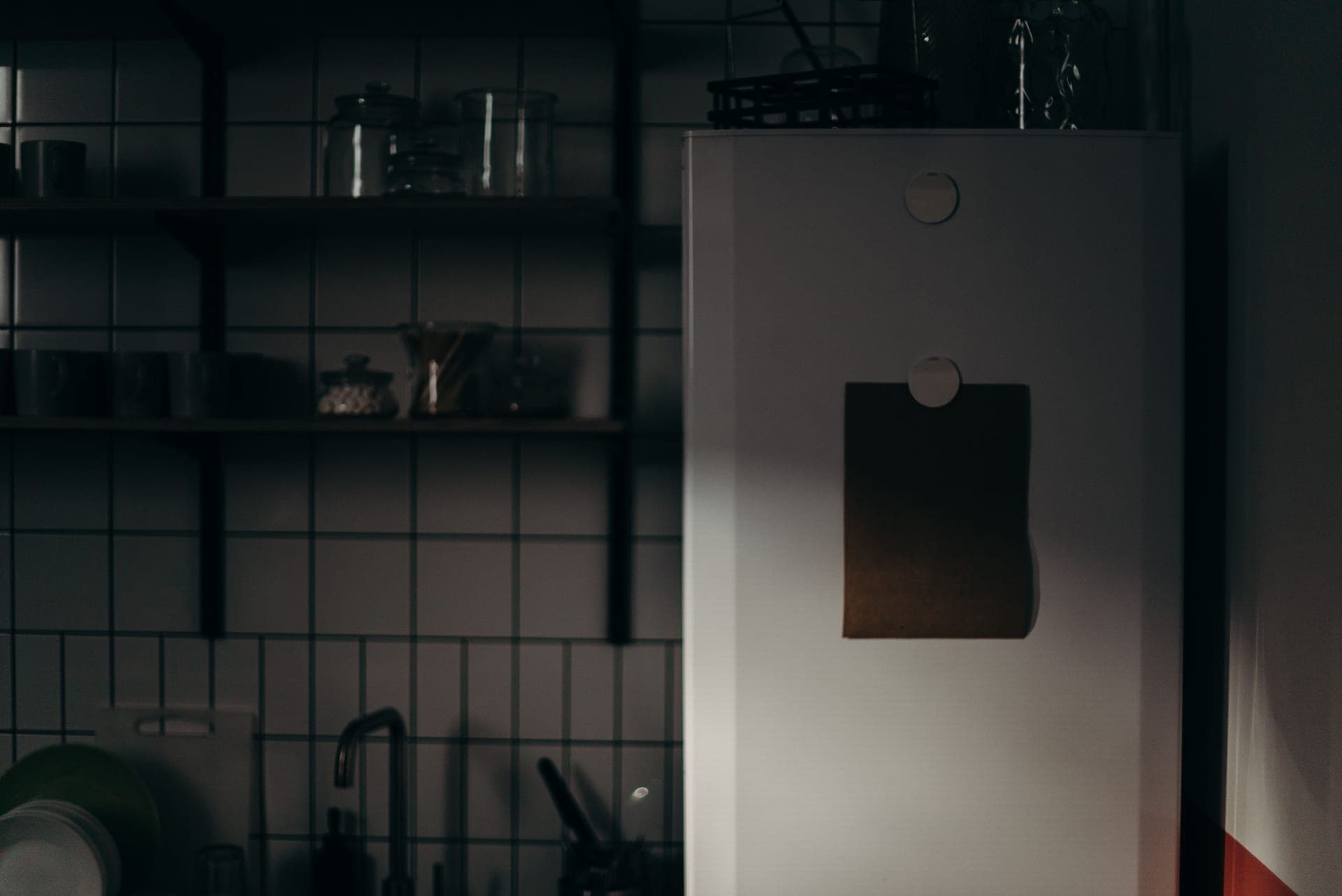 A covered glass jar on a refrigerator shelf beside other containers