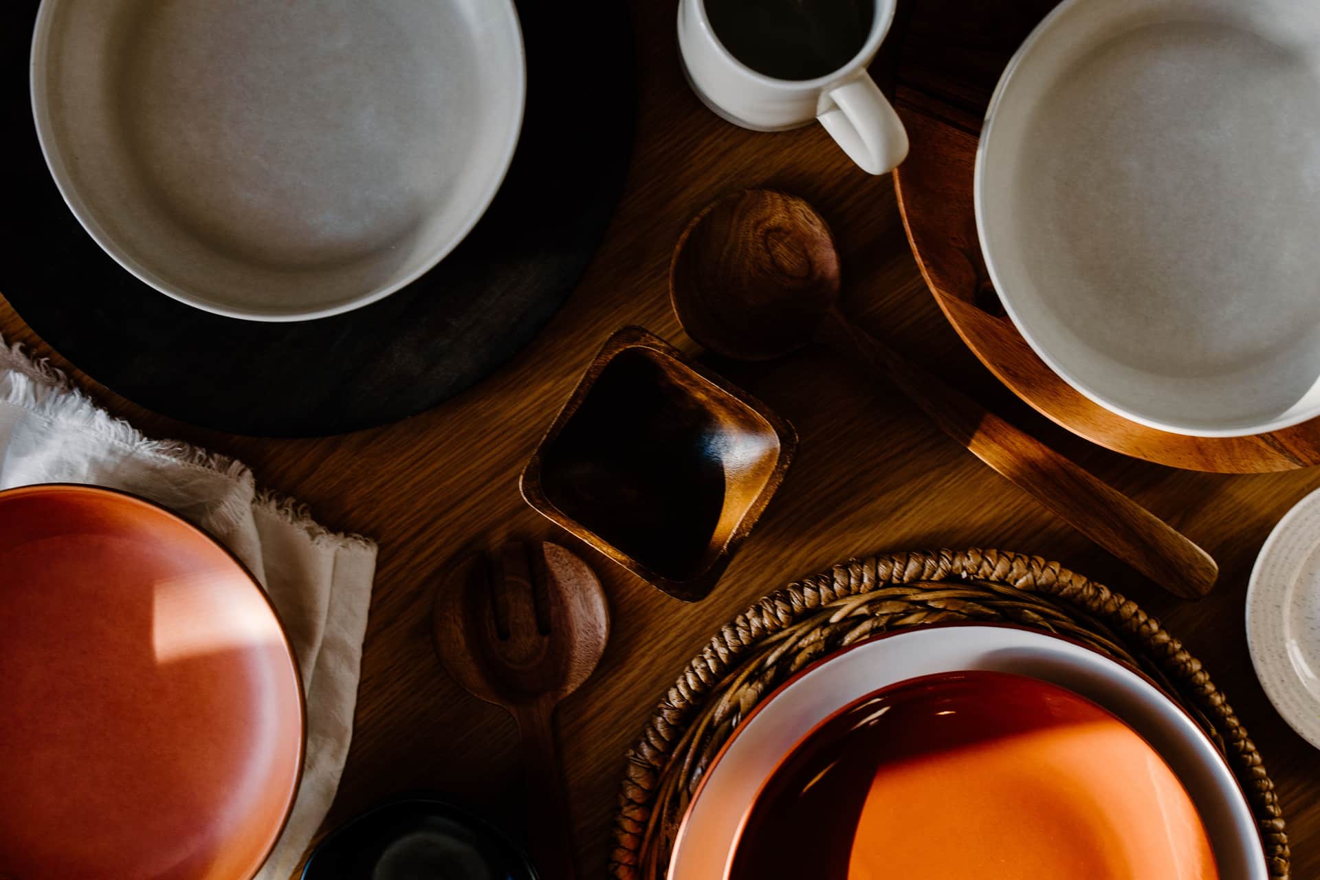 Kitchen utensils arranged individually on a plain wooden table