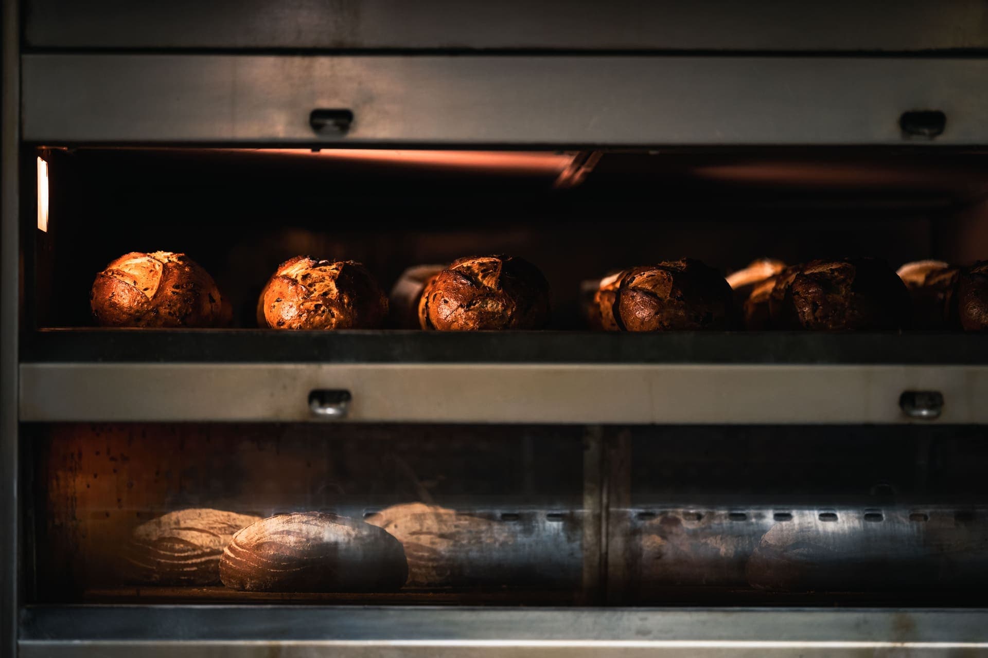 Loaves of artisan bread baking inside a hot oven