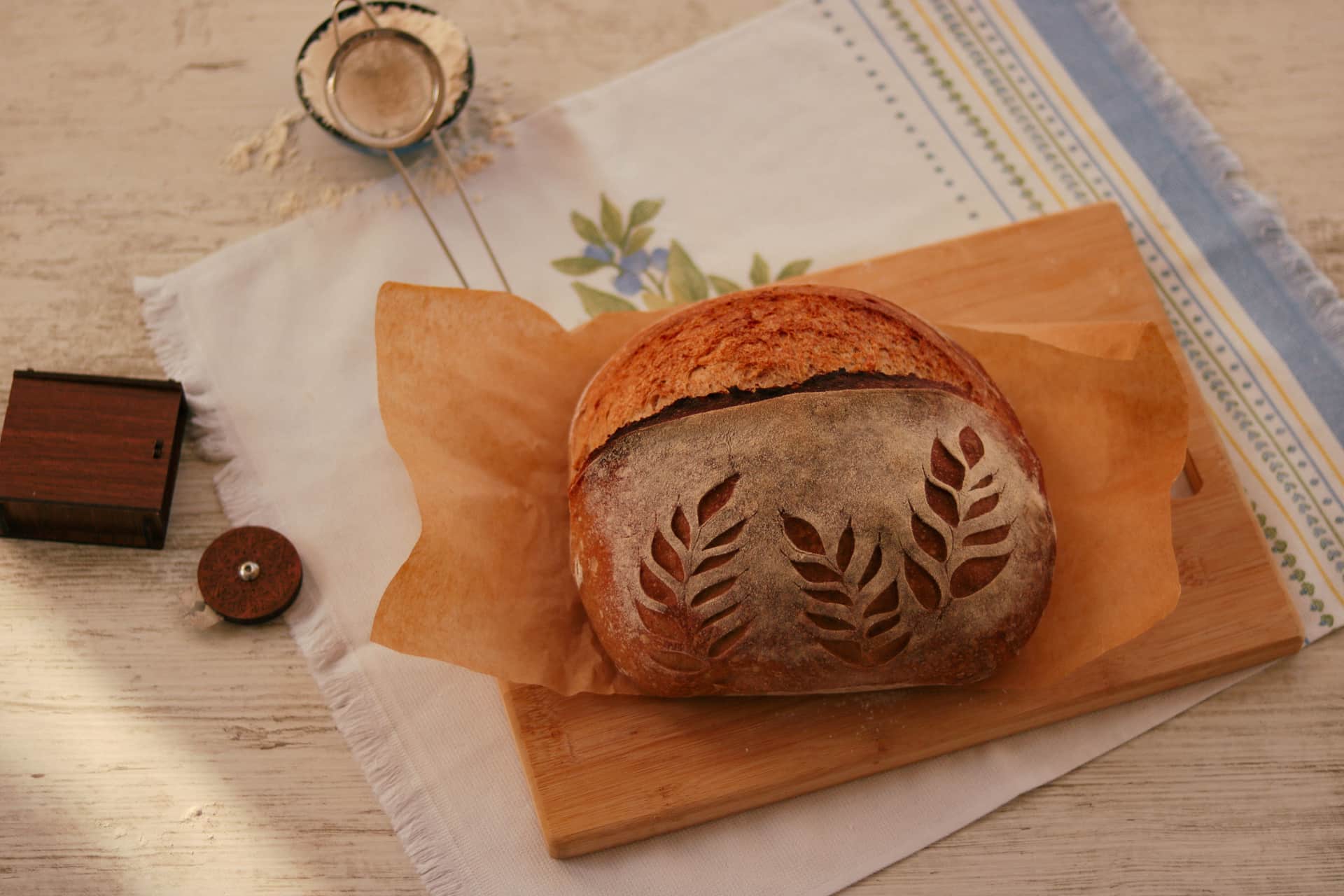A baked sourdough loaf showing a raised scored ridge across the top