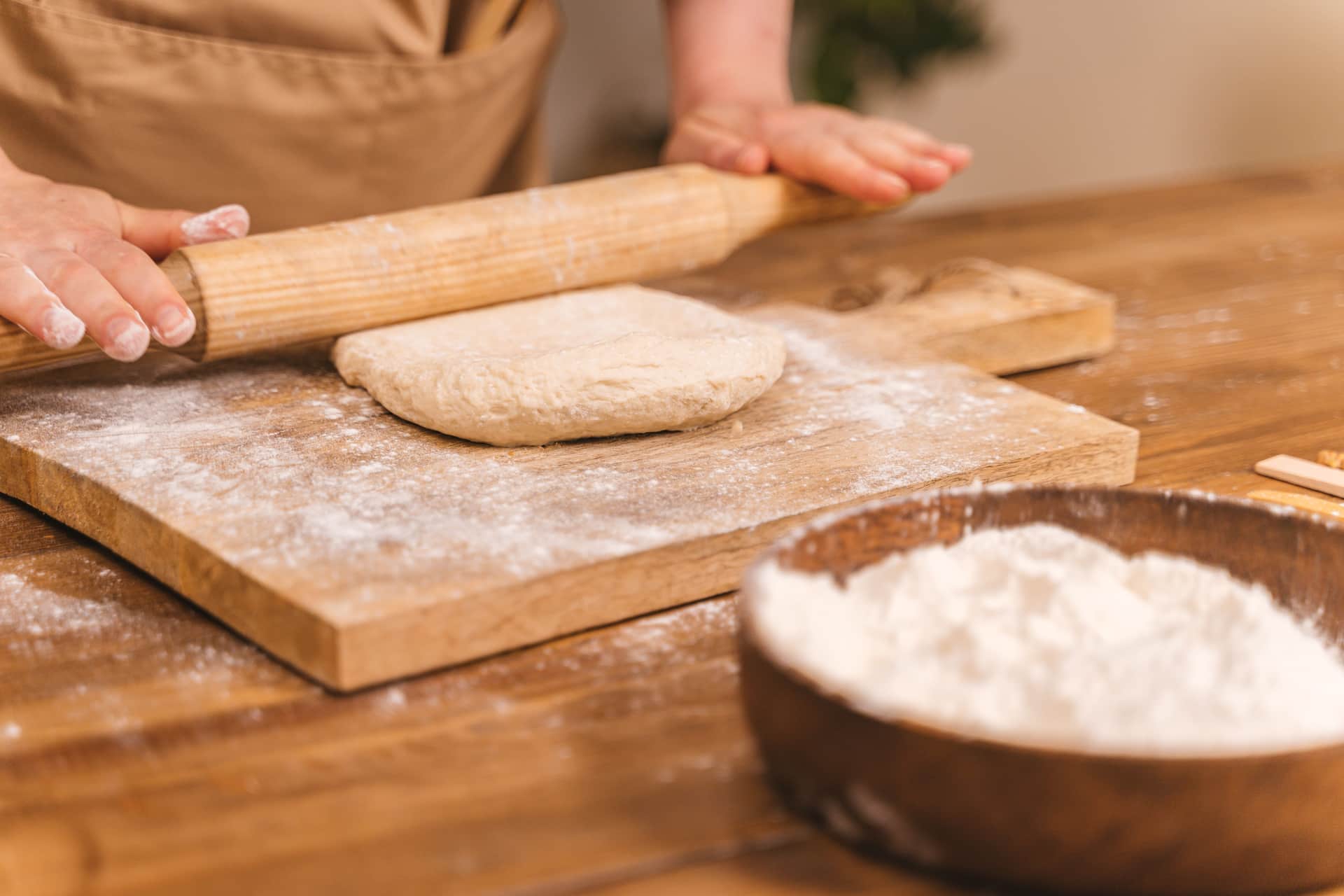 Dough and flour on a wooden work surface during shaping