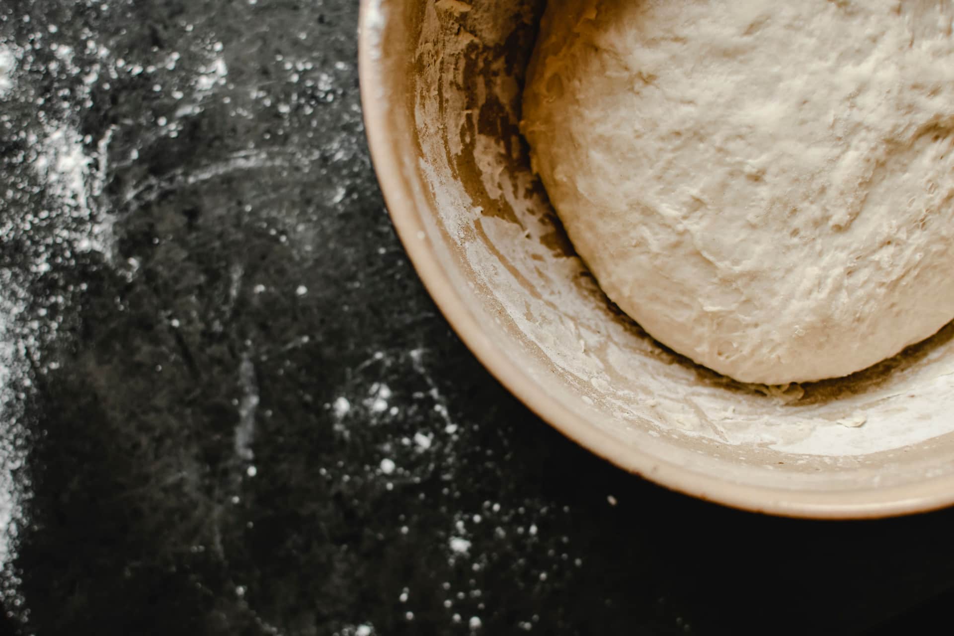 Bread dough rising under a cloth in a mixing bowl