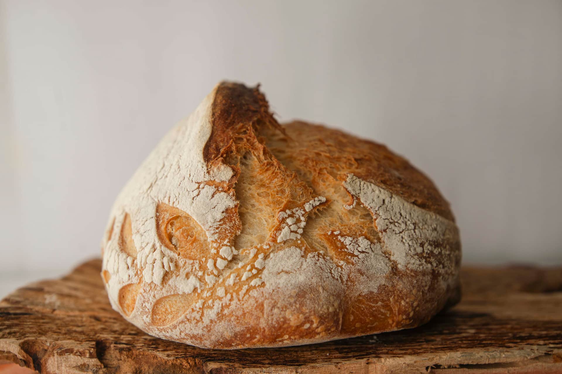 A finished sourdough loaf on a rustic wooden board