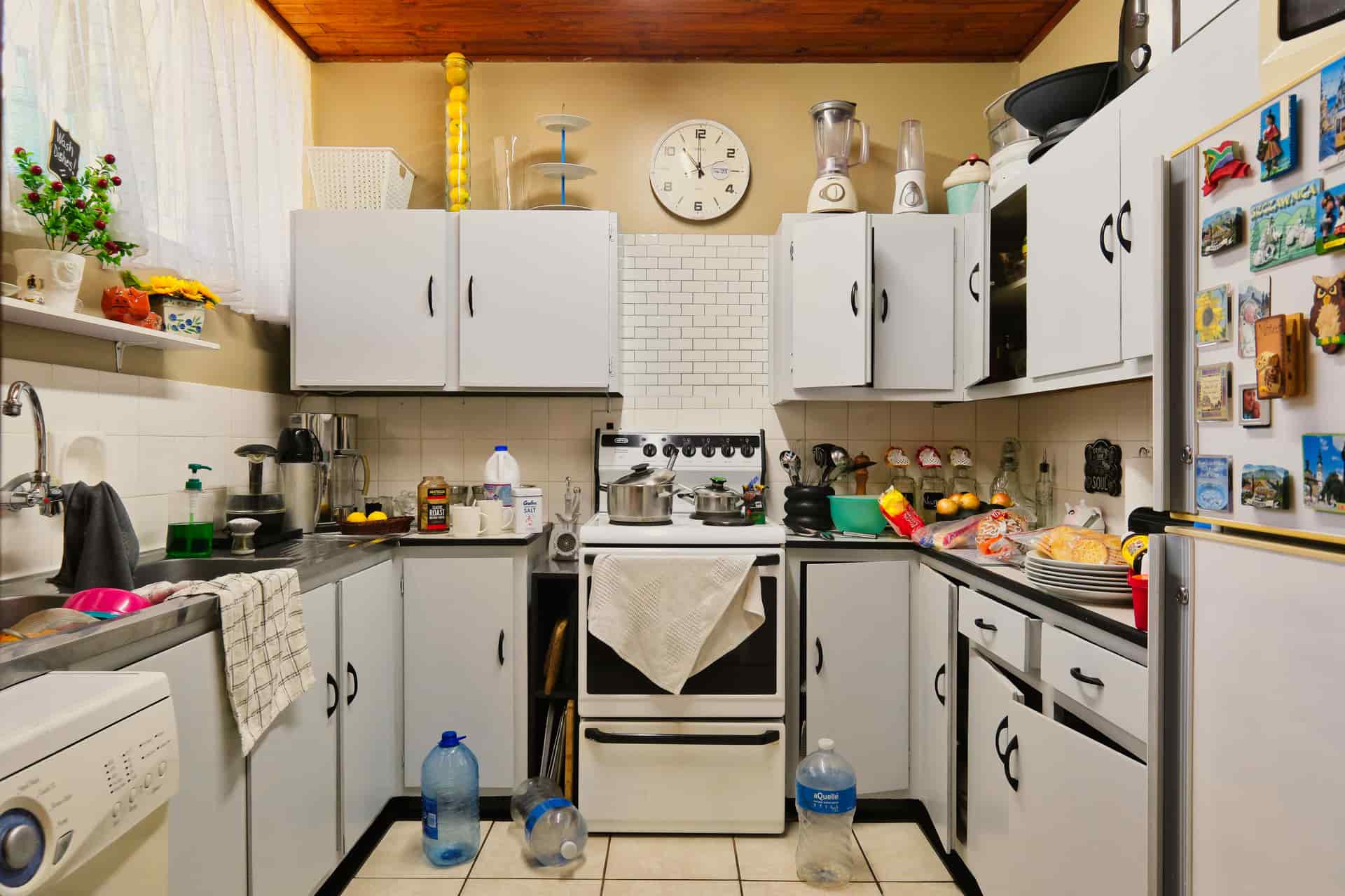 A cluttered kitchen shelf holding assorted unused utensils
