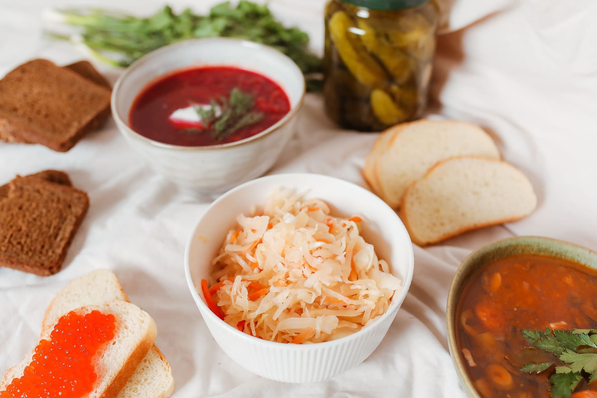 Shredded cabbage and coarse salt in a wide bowl beside a clean glass jar